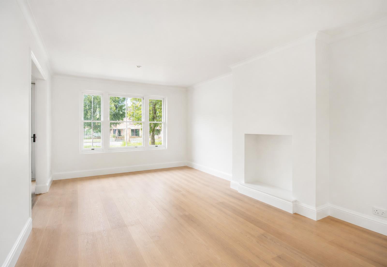 Same living room after professional repainting by Premo Decor, with crisp warm white walls and freshly painted trim