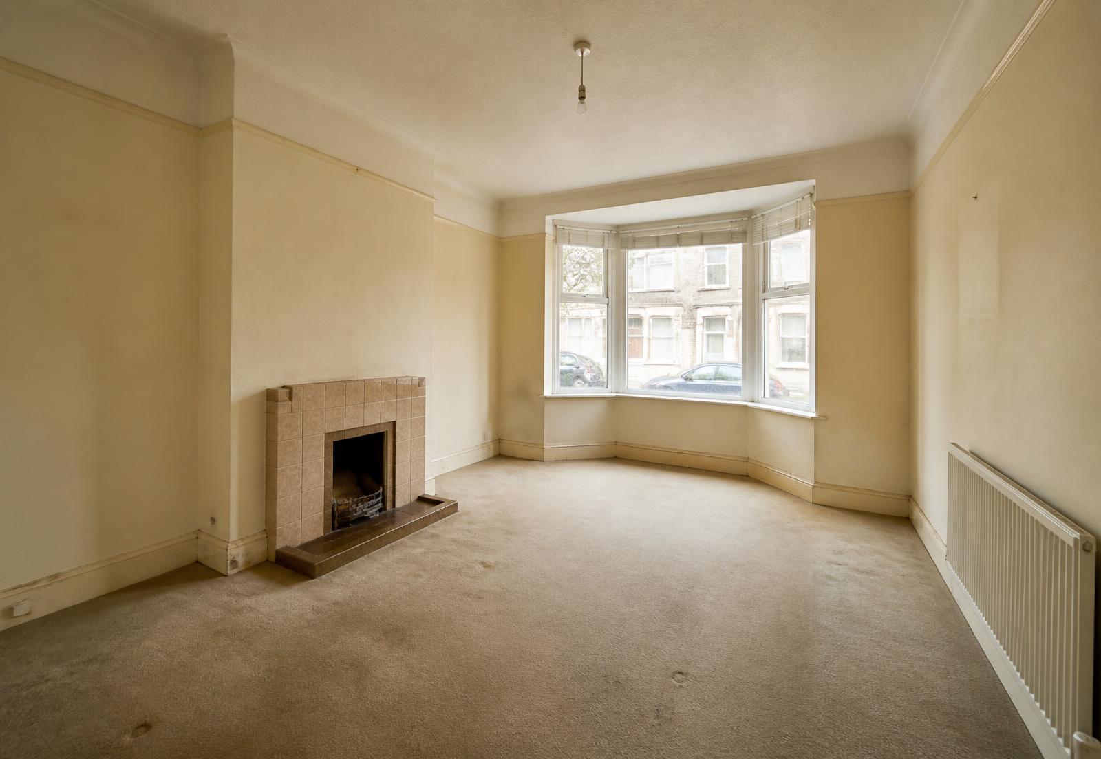 Living room before painting, with dull, dated and worn wall paint